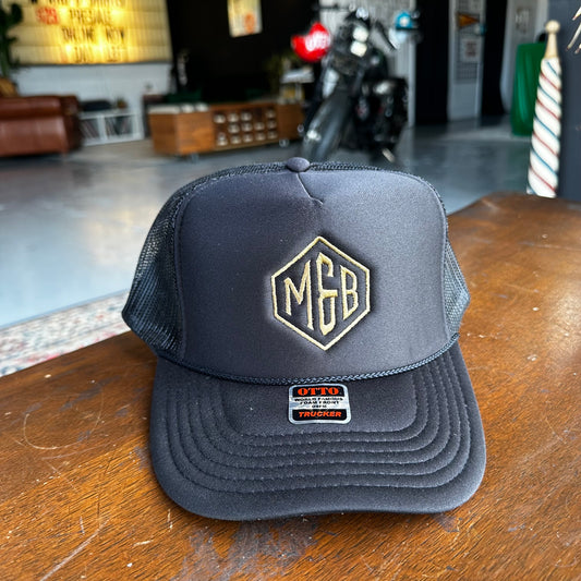 Marcus & Beatty Monogram Foam Trucker Hat, front view with prominent 'M & B' initials in gold, foam panel, Otto high-profile design.